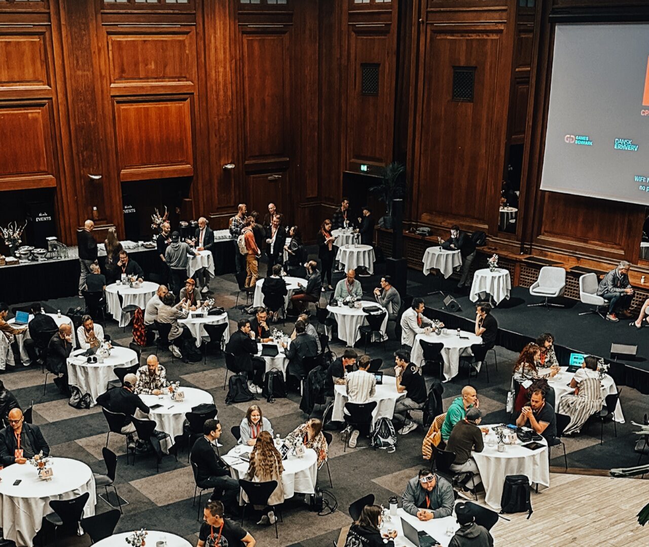 Møde med mange deltagere og borde i forbindelse med Meetup hos Games Denmark. Netop møder og netværk er en del af Track2Exit.