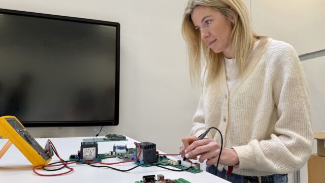 mojo2 Kvinde sidder ved bord og lodder elektronik