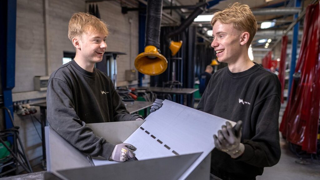 Overskudsmateriale håndteres af to unge medarbejdere